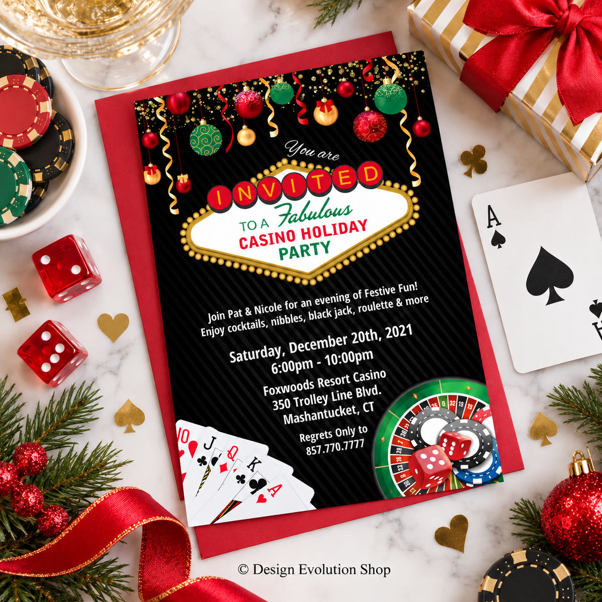 A festive casino-themed birthday invitation card is displayed in a styled flat-lay with red envelopes, playing cards, dice, ornaments, and gift boxes on a marble surface. The invitation features a black background with gold glitter, colorful holiday ornaments, a marquee-style text panel reading 'INVITED TO A Fabulous CASINO HOLIDAY PARTY,' and casino game graphics including roulette and poker chips.