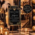 Art Deco style welcome sign on an easel in a decorated event venue. The black sign features gold geometric borders and elegant white text reading 'Welcome to Jasper's 60th Birthday' with date and location below.